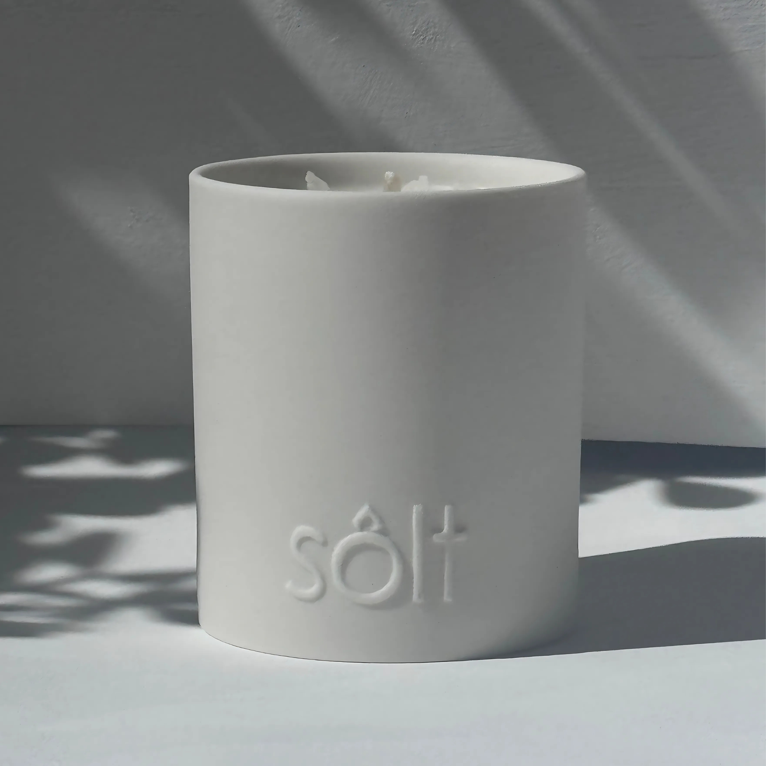 Large stoneware candle, unlit.The Paloma candle. Reads SOLT on the front of the vase.