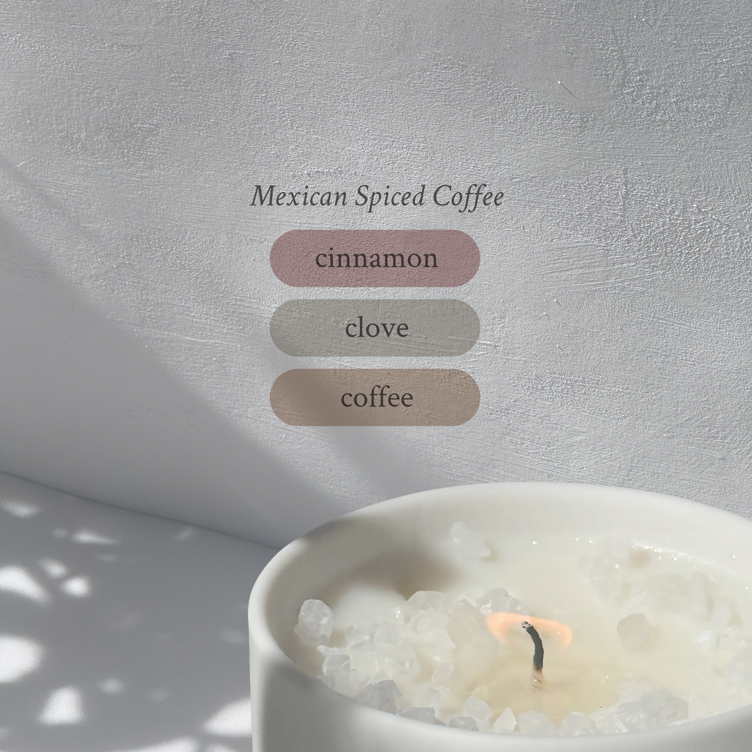 Large stoneware candle, lit, it’s top covered in rock salt. The title reads “Mexican Spiced Coffee”, and underneath is the scent profile: cinnamon, clove, coffee.